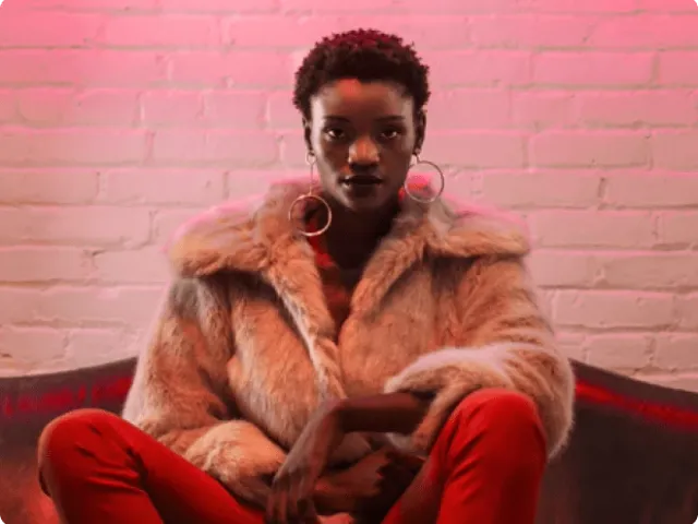 a woman in a fur jacket sitting on a couch