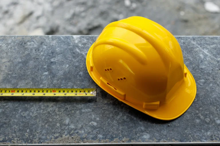 A hard hat next to a tape measure