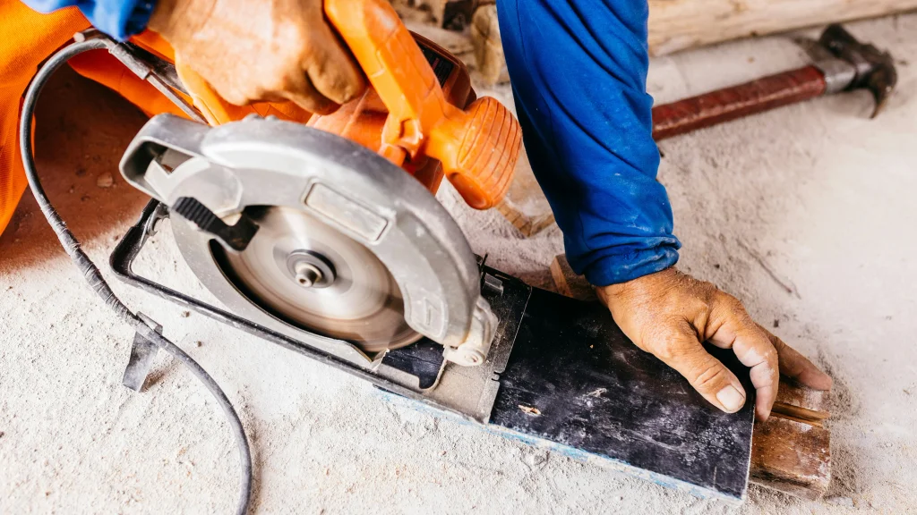 A hand holding a power saw to cut through stone