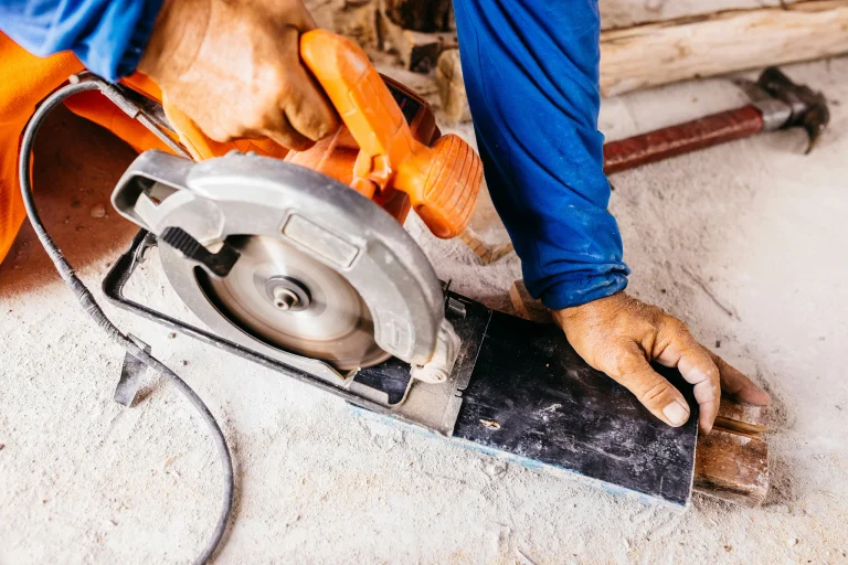 A hand holding a power saw to cut through stone