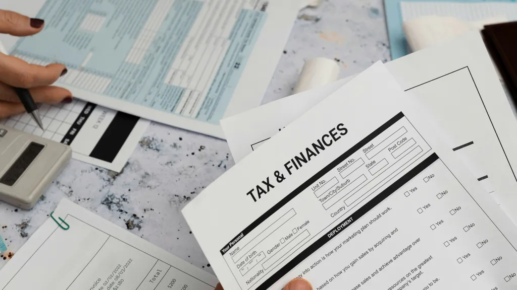Hand holding tax and financial paperwork