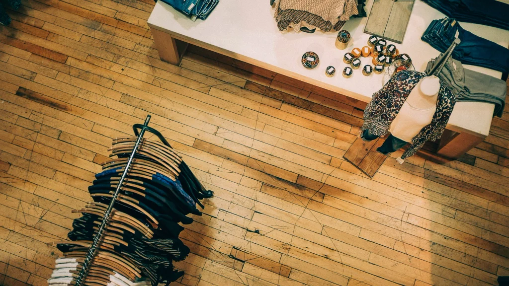 Overhead view of a small clothing boutique with merchandise on a rack and a table