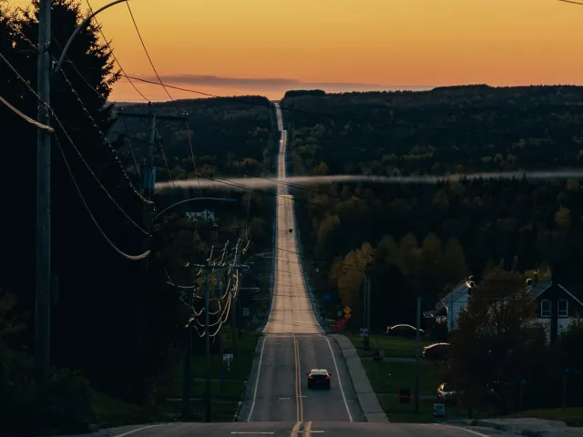 A view of a road heading straight off into the sunset