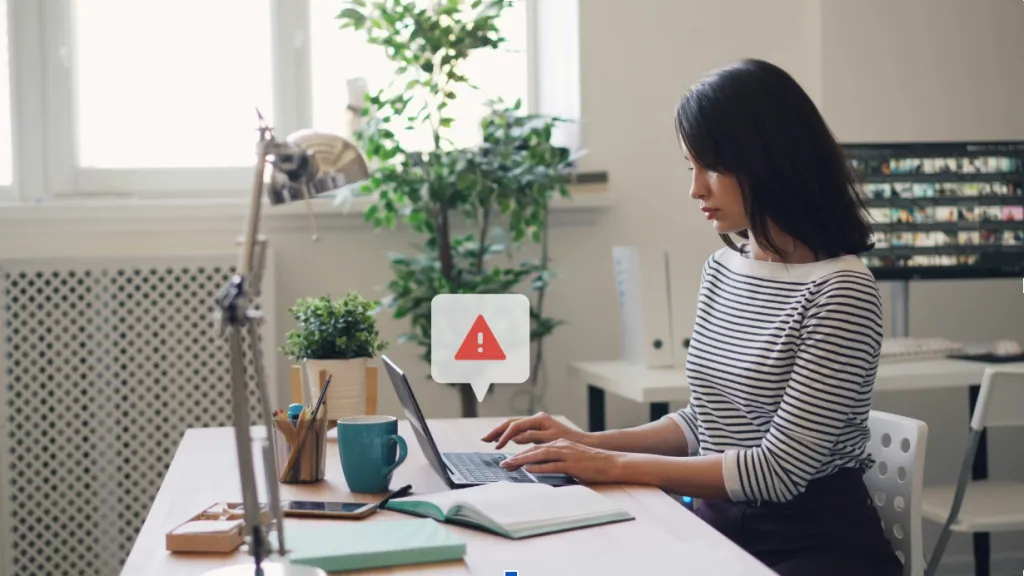 Image for how to avoid business loans scams of a women on a comouter at a desk