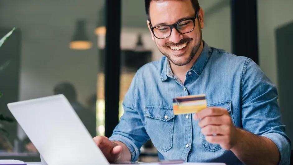 Self employed man looks at credit card