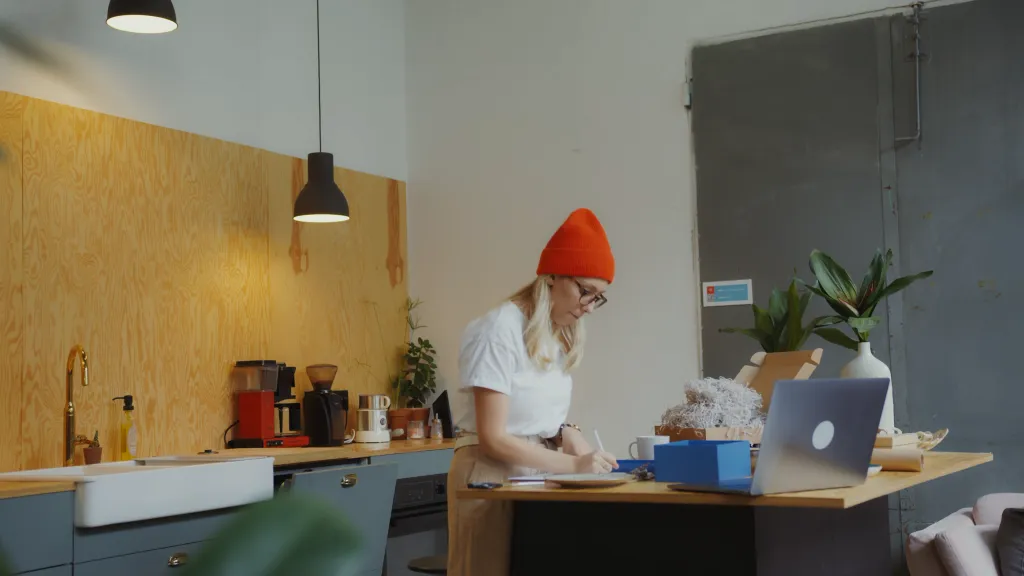 Woman in orange hat working at a standup desk