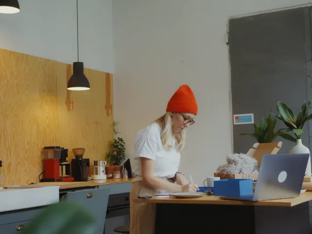 Woman in orange hat working at a standup desk