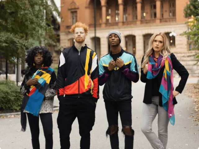 four people standing and modeling clothes and scarves