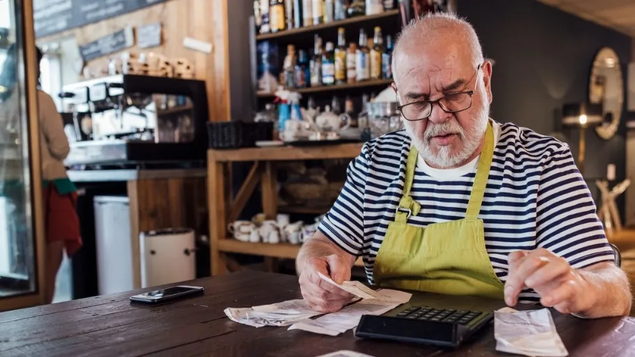 Male small business owner calculating taxes