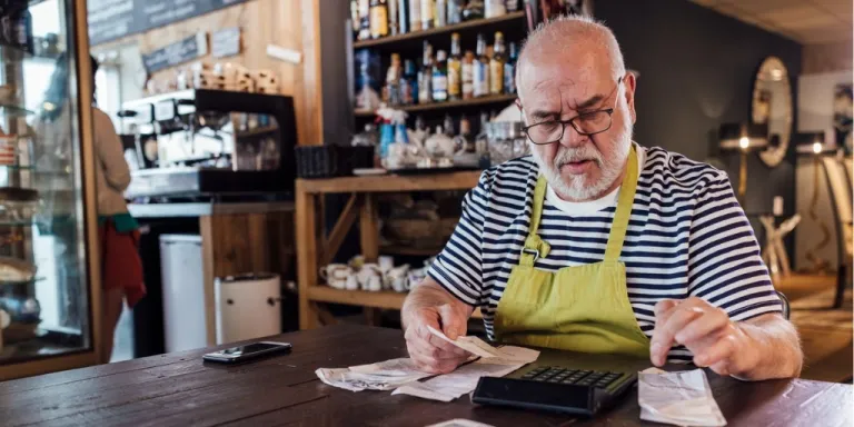 Male small business owner calculating taxes