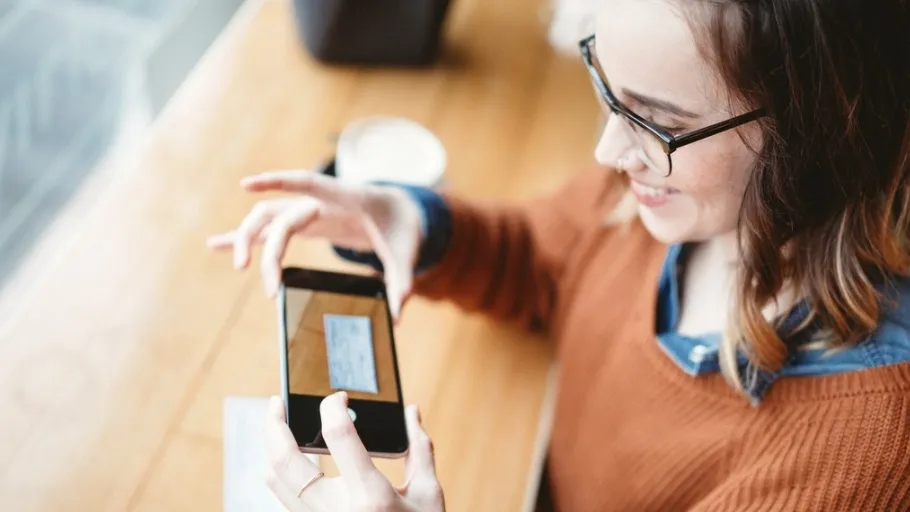 Small business woman employee cashing a check virutally with her cellphone