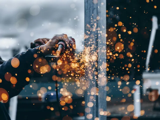 Hands and an unfocused image of sparks flying