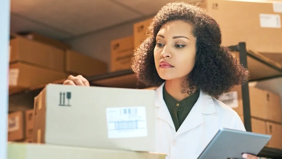 Woman in a medical jacket checking medical supplies in a closet