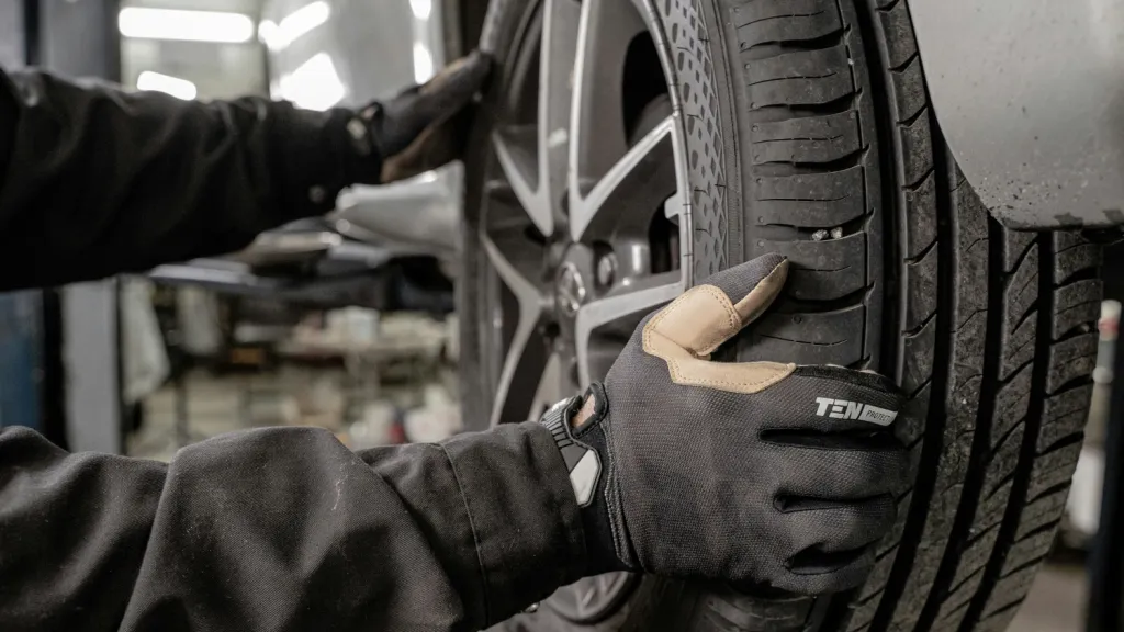 gloved hands holding a wheel, mechanic