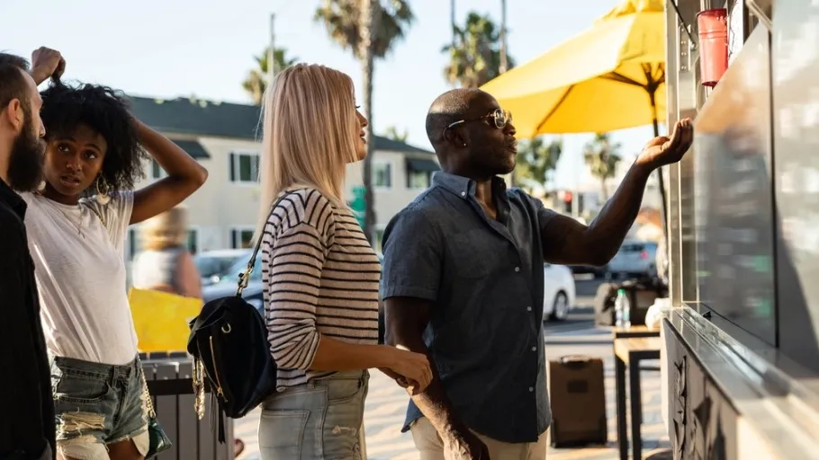 A man and woman purchasing food from a food truck in california