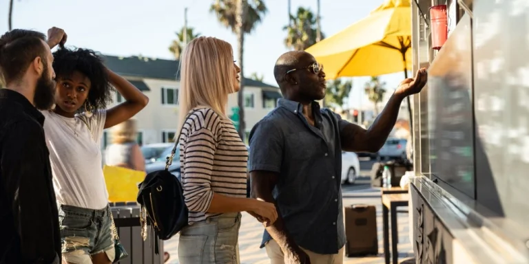 A man and woman purchasing food from a food truck in california