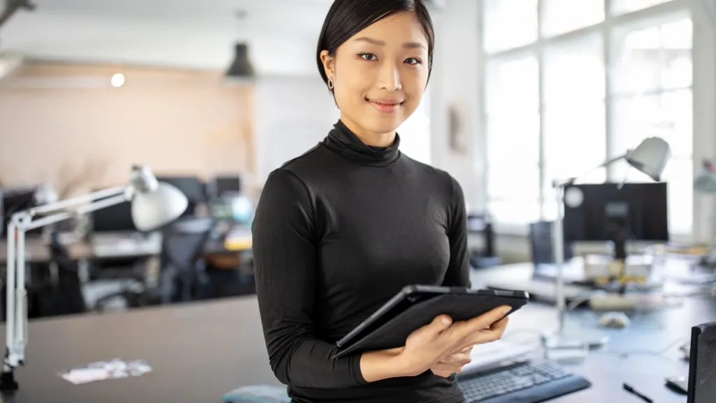 business owner smiling with tablet separating business and personal expenses