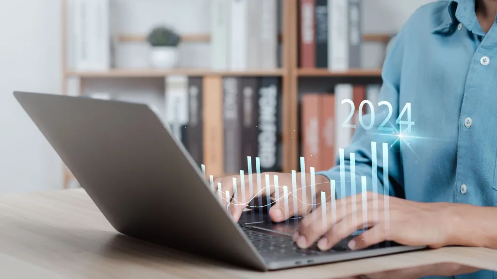 small business owner sitting at lap top researching 2024 trends