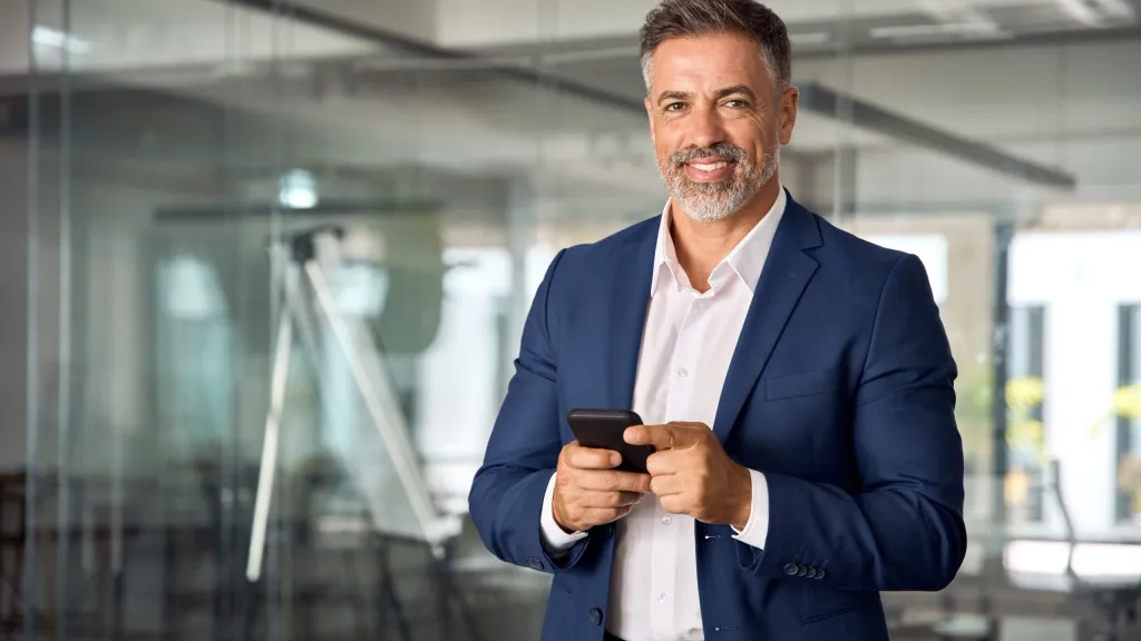Male business owner in a blue suit smiling to illustrate article about business credit score factors.
