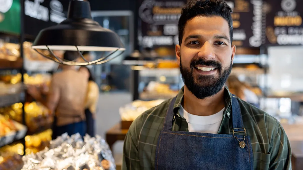 business owner smiling for article about refinancing debt