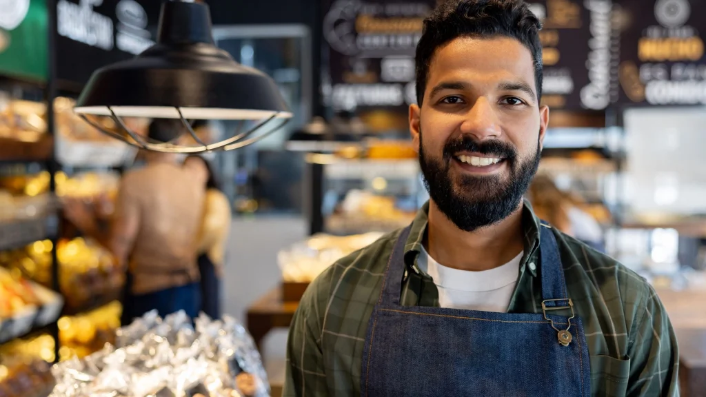 business owner smiling for article about refinancing debt