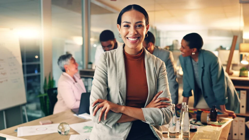 Dark haired business woman with arms crossed smiled to illustrate article about loans for new businesses