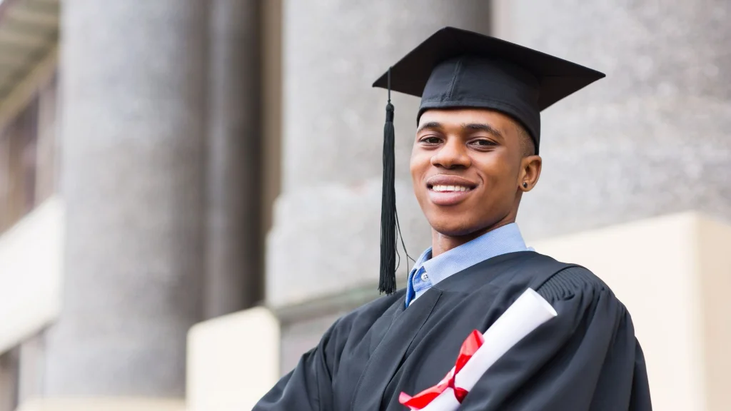 Man in graduation cap and gown to illustrate article about whether an MBA is worth it