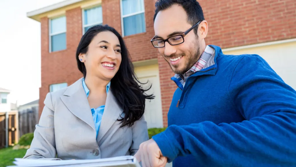 business owners reviewing business checking account standing in front of airbnb house
