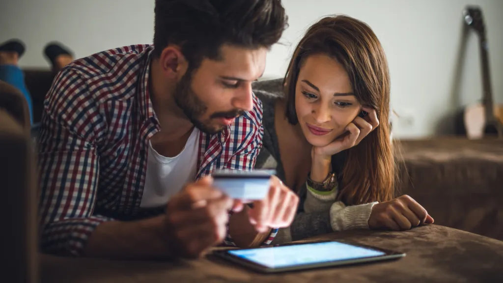 Couple looking at tablet device reviewing small business loan brokers