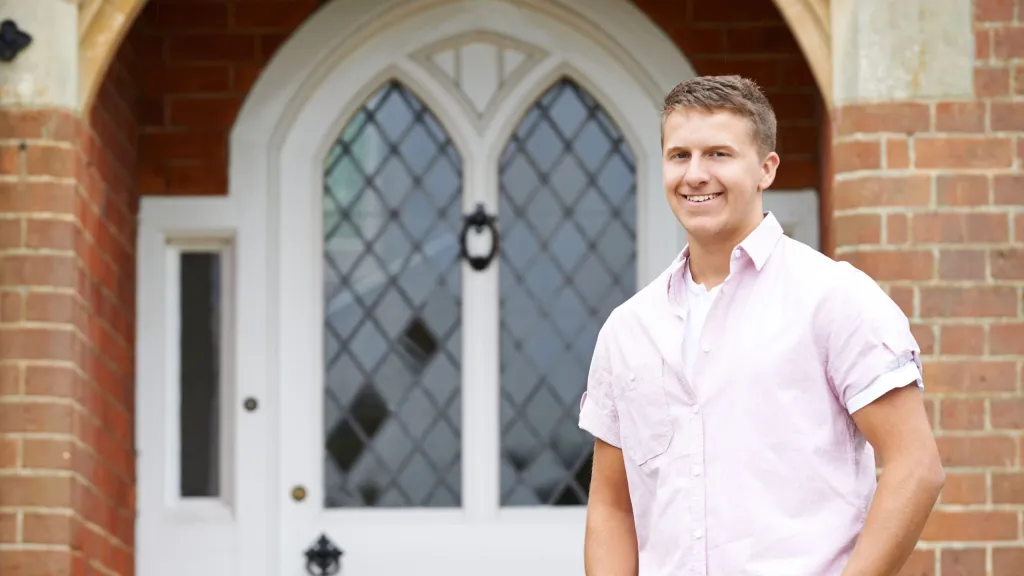 Man standing in front of house and smiling to illustrate article about using home equity to start a business