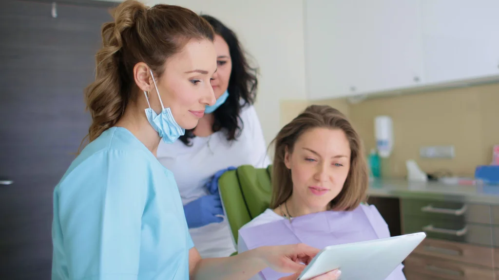 A medical professional helps a patient read paperwork