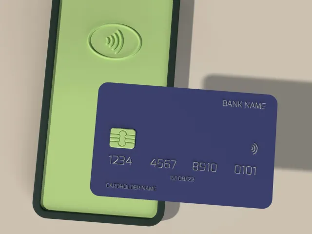A blue credit card against a green phone screen accepting payment