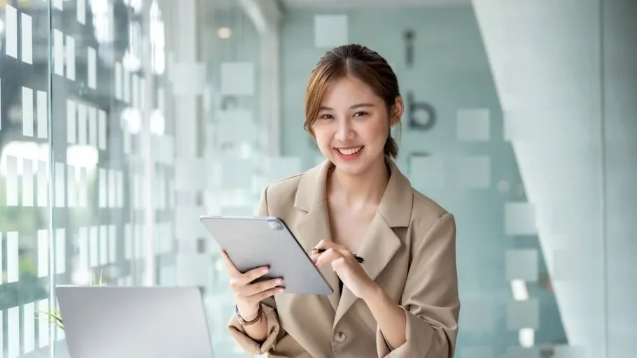 Young woman smiling with a tablet to illustrate article about personal vs business insurance