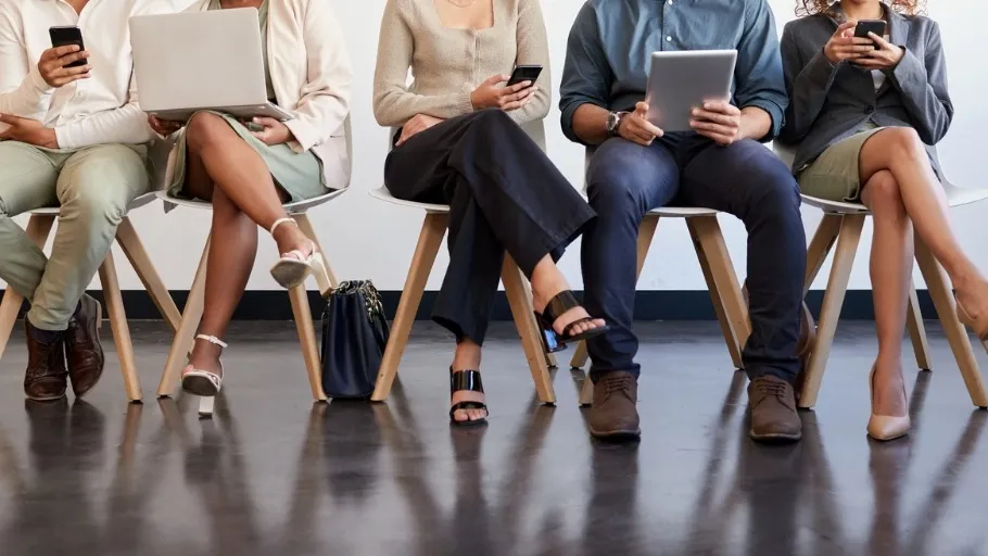 A row of people sitting in a chair at a staffing agency