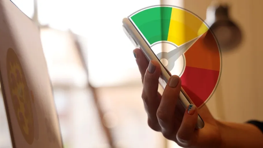 Person holding a cellphone with a credit score range graphic