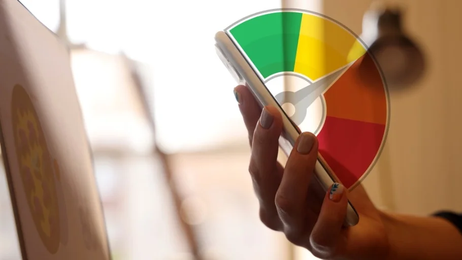 Person holding a cellphone with a credit score range graphic