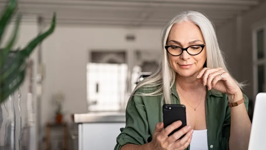 Woman looking at phone to switch business bank account