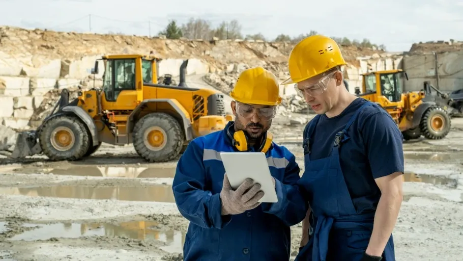 Two workers in hardhats go over an equipment financing line of credit offer
