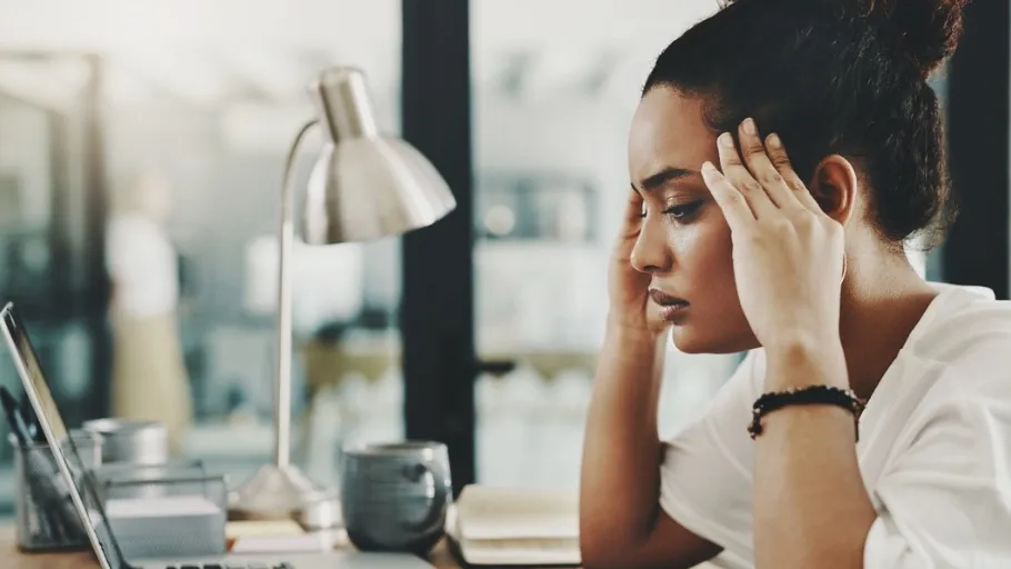 Small business woman sitting at a desk in front of a computer feeling frustrated