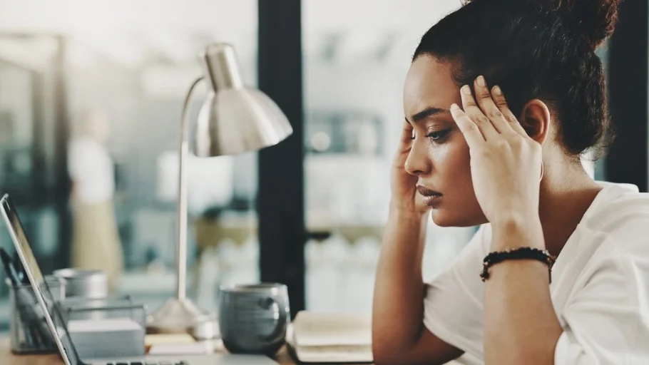 Small business woman sitting at a desk in front of a computer feeling frustrated