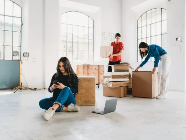 A group of small business owners unpacks boxes while one starts an llc