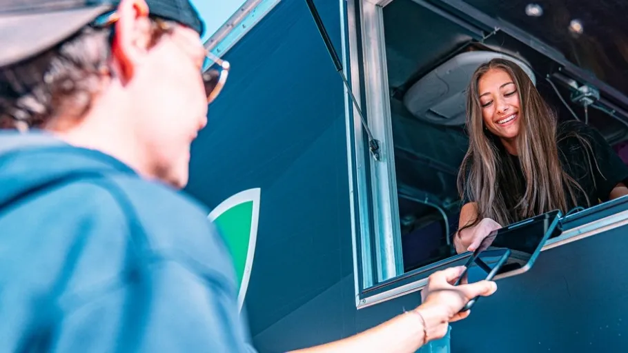Female Food truck small business owner receiving payment from a customer