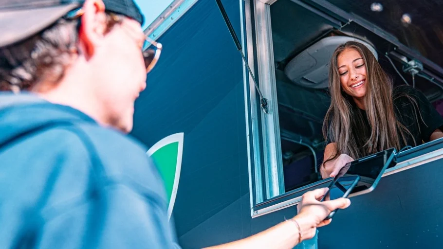 Female Food truck small business owner receiving payment from a customer