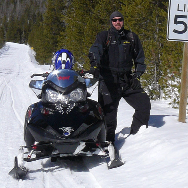 Lew posing by a snowmobile