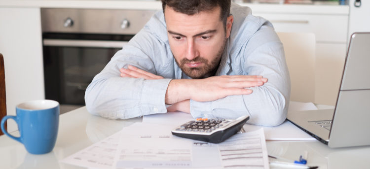 Frustrated man calculating bills and tax  expenses