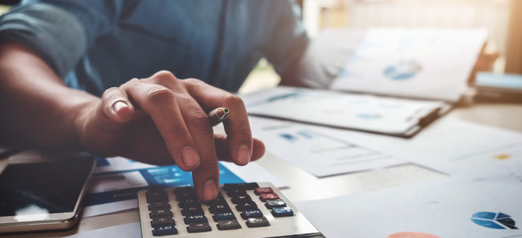 Business accounting concept, Business man using calculator with computer laptop, budget and loan paper in office.