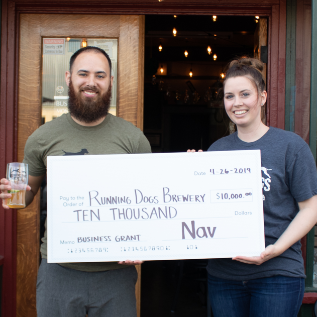 Business owners holding a giant check