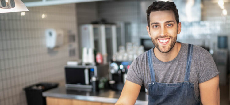 Portrait of a barista standing behind the counter in a cafeteria