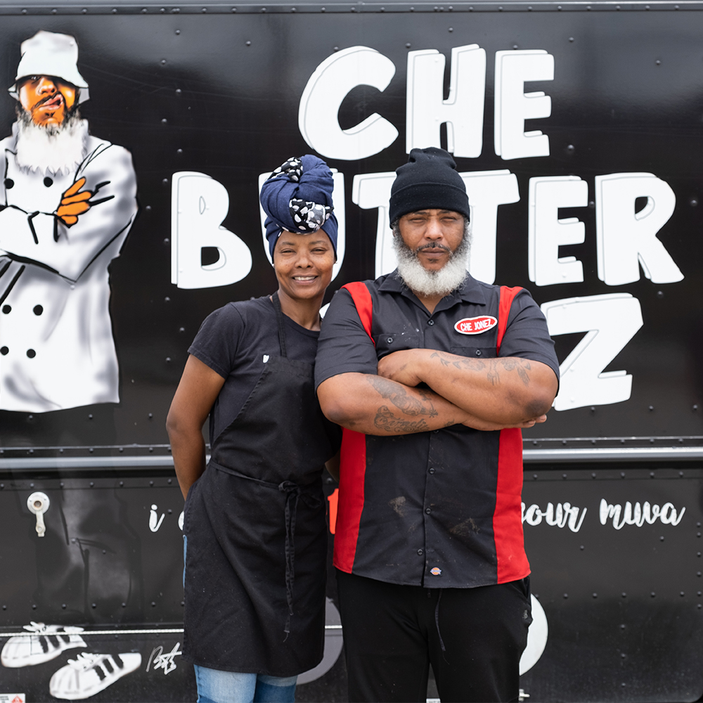 Business owners posing by a food truck