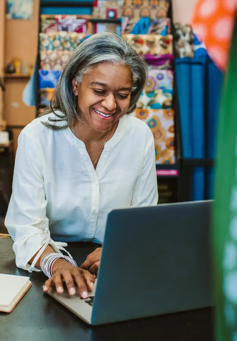 Fabric store owner using Nav Prime on computer